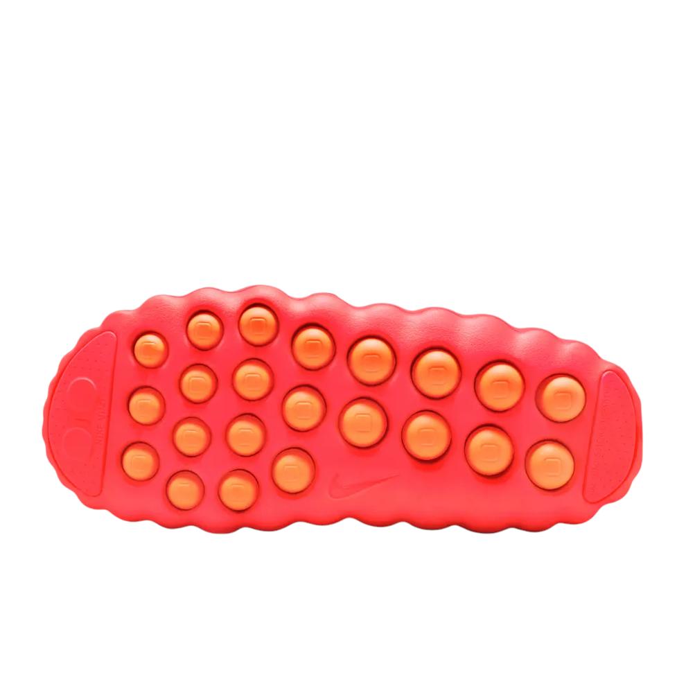 JeevzPlug Nike Mind 001 Slide in Solar Red showing the textured, circular-patterned outsole for grip.