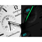 JeevzPlug Swatch x Omega Moonswatch 1965 watch dial showing white face, black bezel, and glowing blue luminous details.