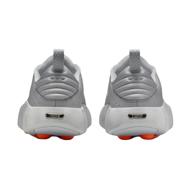 JeevzPlug Nike Mind 002 Light Smoke Grey sneakers showing the rear view with metallic heel branding and orange outsoles